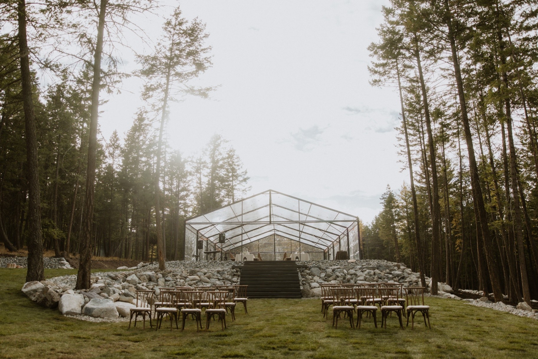 Ceremony seating on the lawn with the tent and lake behind