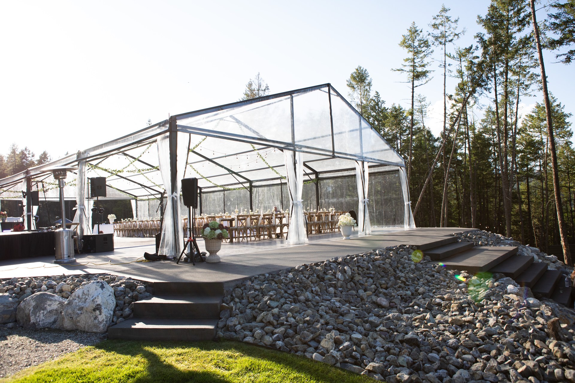 The clear-top tent on its stone terrace in afternoon sun