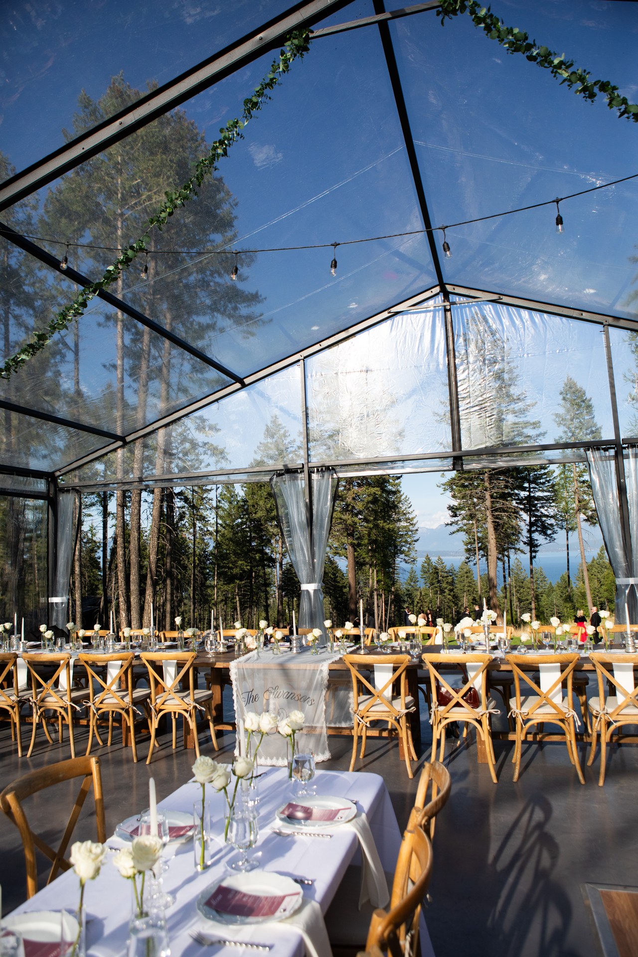 Inside the clear tent with the tables set and Flathead Lake beyond